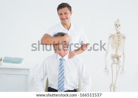 Portrait of a male chiropractor doing neck adjustment in the hospital