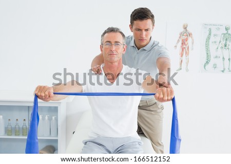 Male therapist massaging mans shoulder in the hospital