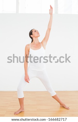 Full length of a fit young woman doing pilate exercises in the fitness studio