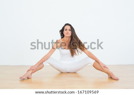 Full length portrait of a slim young woman with long hair in fitness studio