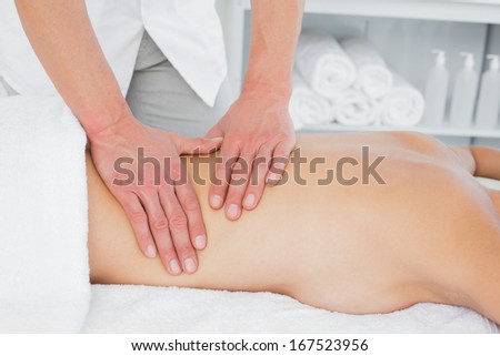 Close-up of a male physiotherapist massaging woman\'s back in the medical office