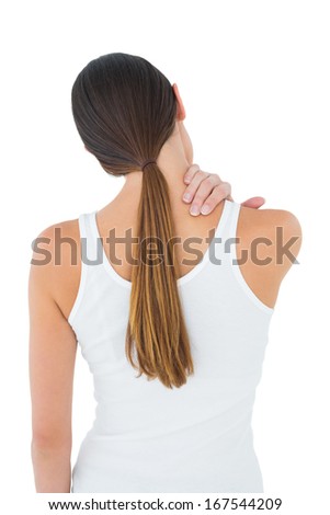 Rear view of a casual young woman suffering from neck ache over white background