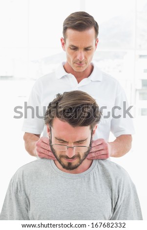 Male therapist massaging a young man\'s neck in the medical office