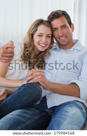 Portrait of a loving young couple sitting on couch at home