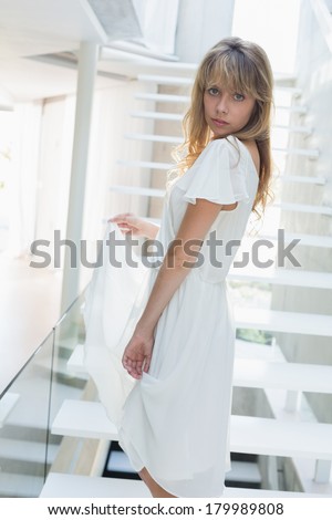 Side view portrait of a young woman standing on stairs at home
