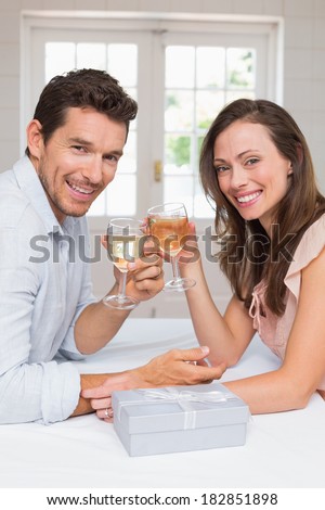 Side view portrait of a loving young couple toasting wine glasses at home
