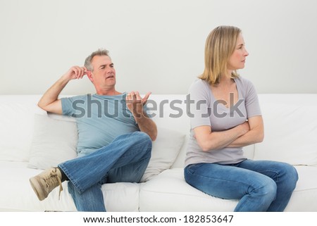Unhappy couple not talking after an argument in the living room at home