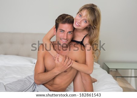 Portrait of a loving young woman embracing man from behind at home