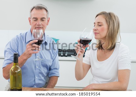 Relaxed couple drinking wine in the kitchen at home