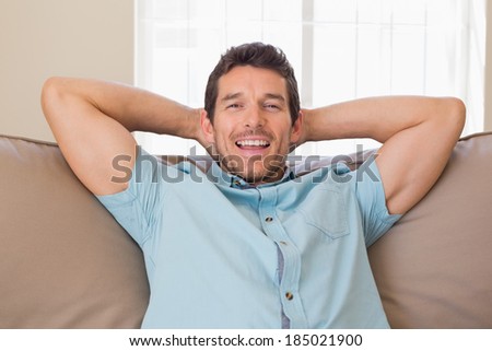 Portrait of a happy relaxed young man sitting on couch at home