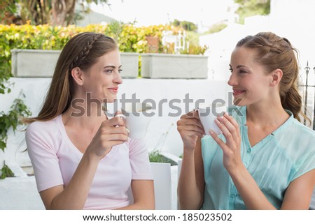 Two happy female friends having coffee at the coffee shop