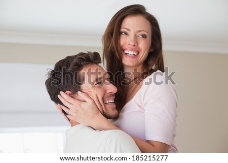Close-up side view of a loving young couple smiling at home
