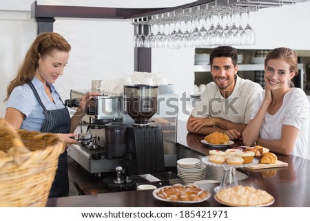 Portrait of a couple with female cafe owner at the coffee shop