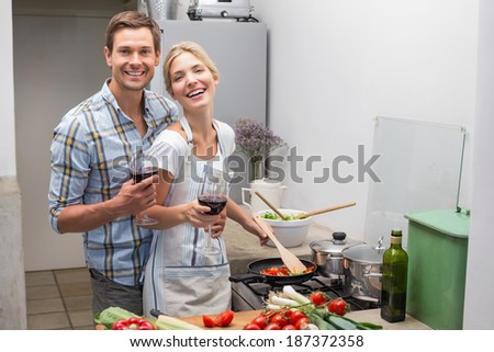 Portrait of a loving young couple with wine glass in the kitchen at home