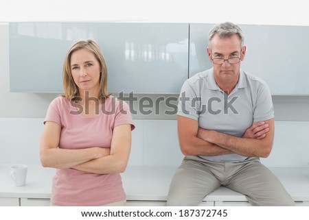 Unhappy couple not talking after an argument in the kitchen at home