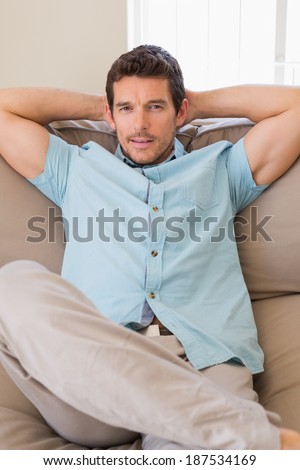 Portrait of a happy relaxed young man sitting on couch at home