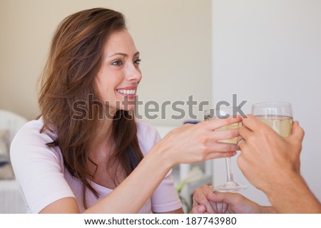 Close-up of a happy loving young couple toasting wine glasses at table
