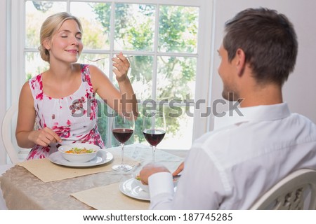 Happy young couple enjoying food at home
