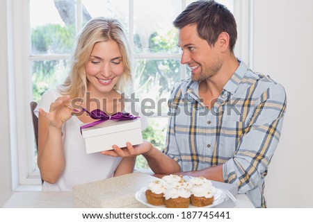 Beautiful young blonde receiving a gift box at home