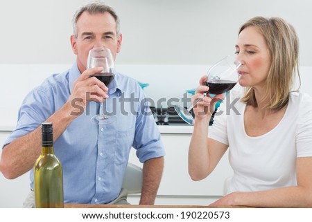 Relaxed couple drinking wine in the kitchen at home
