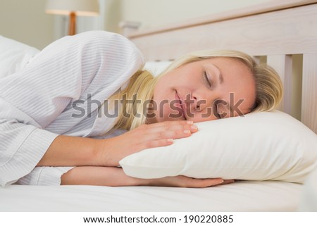 Relaxed woman sleeping in bed at home