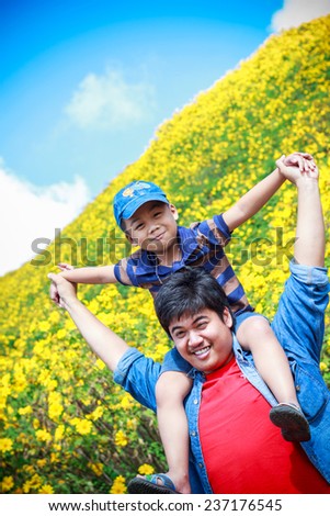 Son sat on father Asians shoulders.