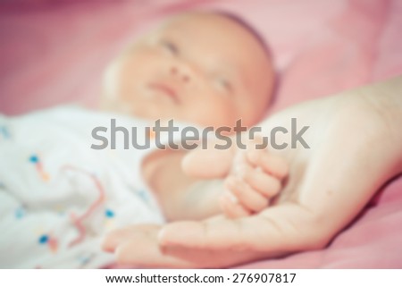 Baby holding Mother hand. Mother\'s Love. blur style