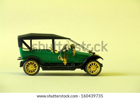 green vintage toy car on a yellow background