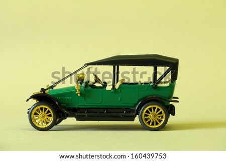 green vintage toy car on a yellow background