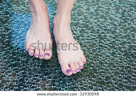 Women's foot on bubbled glass.
