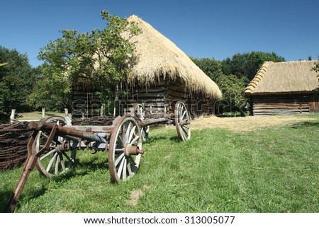 Old wooden hay wagon in front of an old timbered barn in Straznice, Czech Republic.