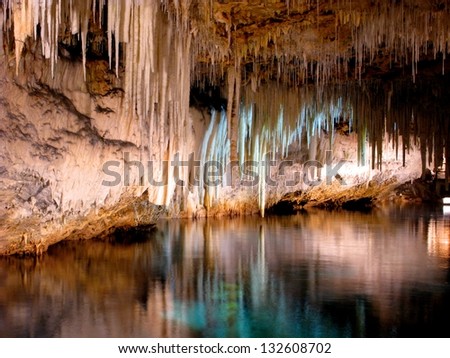 Beautiful Cave Interior With Reflections In Clear Underground Water And Lighting