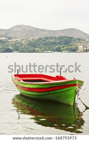 Lonely boat on the lake with mountain landscape