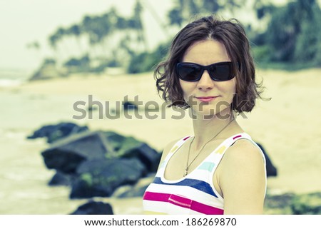 Beautiful young woman portrait on the empty beach at coastline of Sri Lanka, Ceylon. Horizontal image with vintage filter