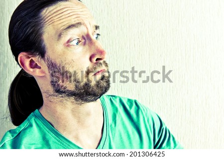 Portrait of a young beautiful long hair man with surprised face expression