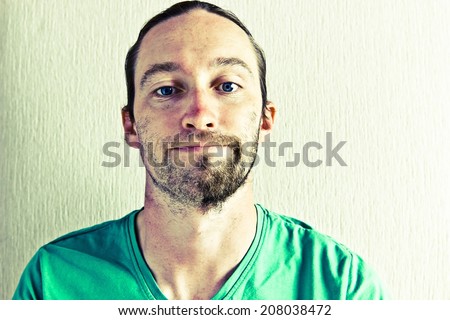 Portrait of smiling young man with half shaved face. Image with vintage filter