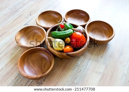 Fresh vegetables in big wooden bowl with small empty bowls