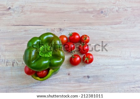 Small tomatoes in cut green pepper with zucchini. Horizontal image. Objects at the left part of image