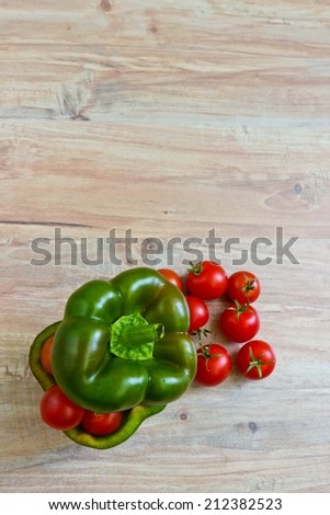 Small tomatoes in cut green pepper. Vertical image