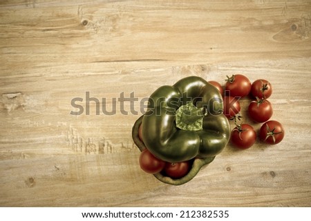 Small tomatoes in cut green pepper. Horizontal image with vintage filter. Objects at the right part of image