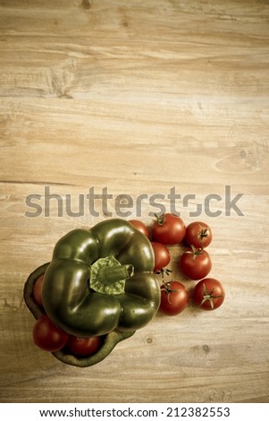 Small tomatoes in cut green pepper. Vertical image with vintage filter