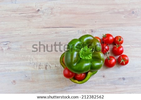 Small tomatoes in cut green pepper. Horizontal image. Objects at the right part of image