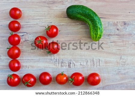Fresh vegetables on wooden background. Conceptual image with tomatoes frame