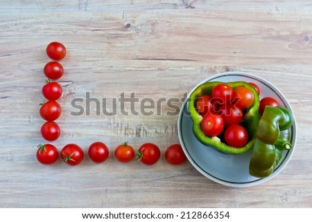 Fresh vegetables on wooden background. Conceptual image with tomatoes frame