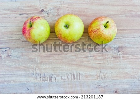 Three apples at wooden background