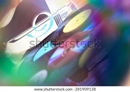 Background with Vinyl record discs ans CD. Focus on background. Multicolored view through CD hole