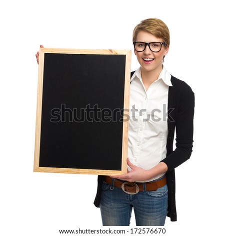 Smiling blond woman in nerd glasses holding black board over hers head. Three quarter length studio shot isolated on white background.