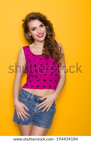 Beautiful smile. Smiling young woman posing. Three quarter length studio shot on yellow background.
