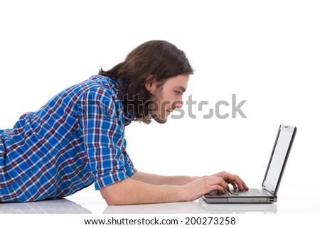 Focused young man working on a laptop. Side view, waist up studio shot isolated on white.