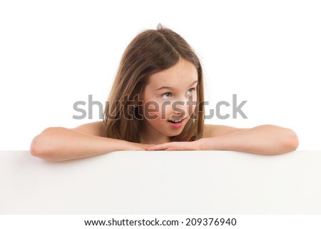 Close up of surprised little girl leaning with arms crossed on blank sheet and looking away. Head and shoulders studio shot isolated on white.